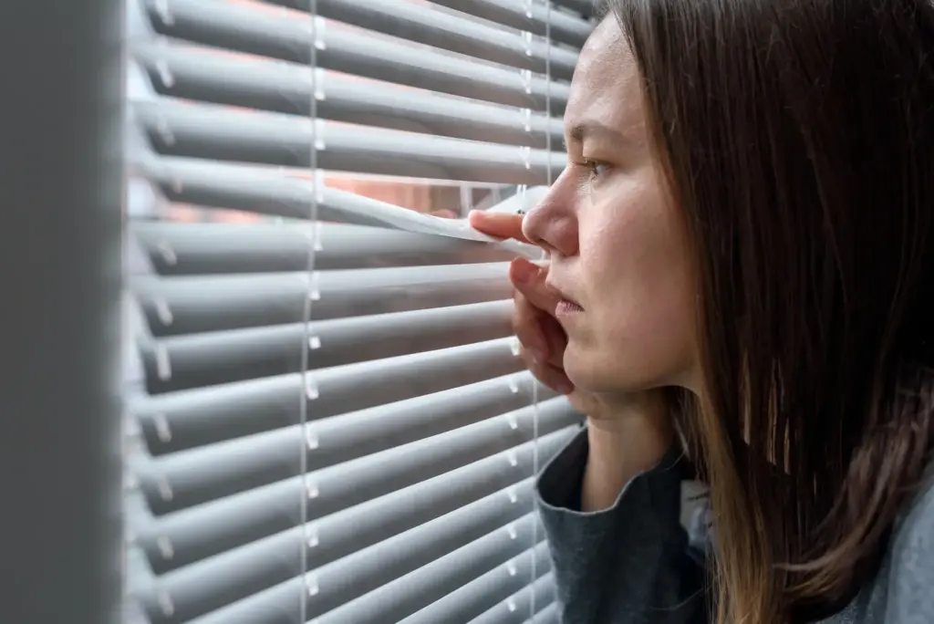 Anxious woman looking to window