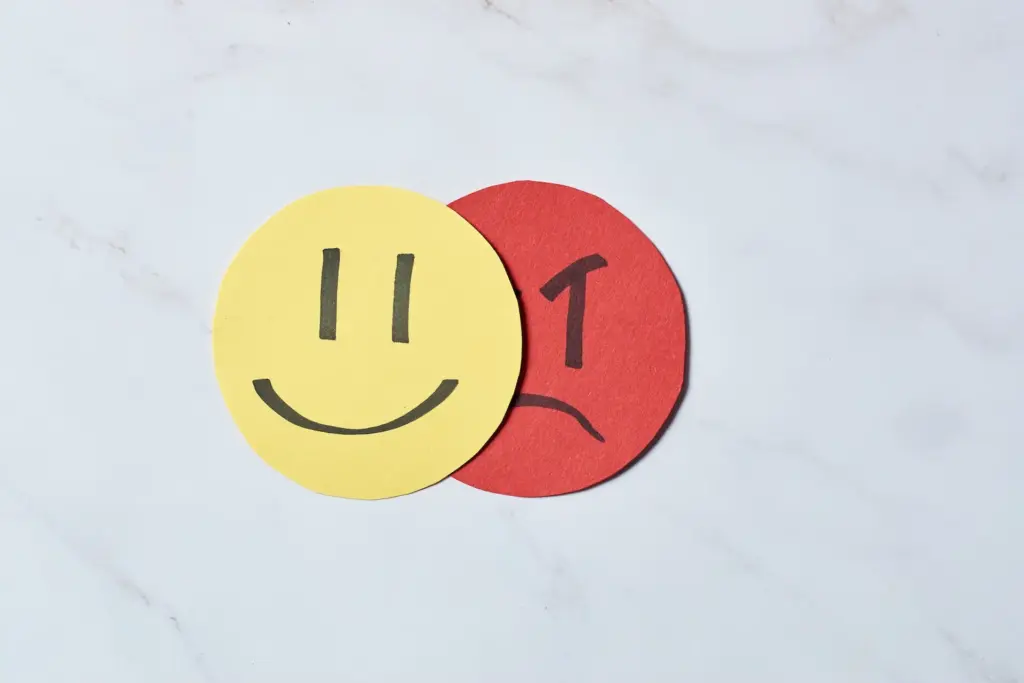 Angry face covered by happy face. Bipolar and stress disorder concept.