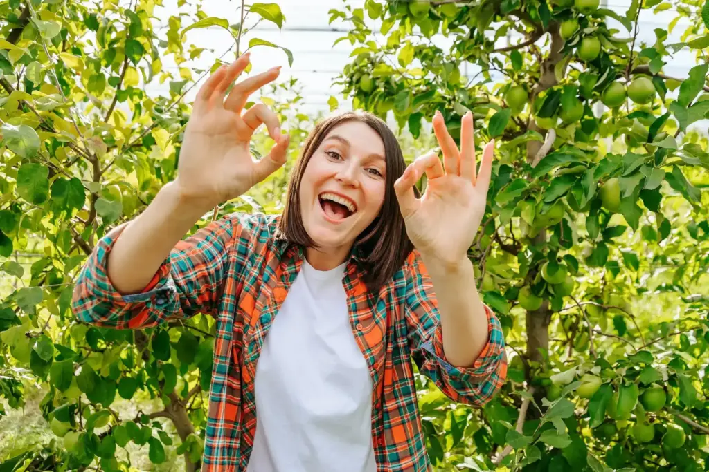 Young woman farmer feels great and shows ok with both hands.